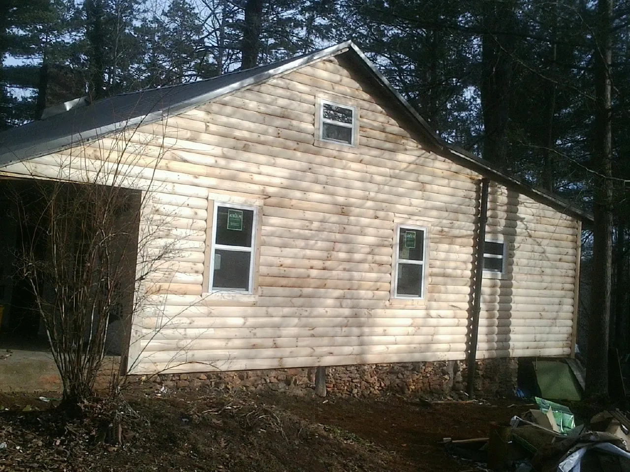 New log siding and dark metal roofing on a gable end in La Grange Park