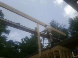 Carpenter setting a ridge beam over a new addition frame — Ice Dam Removal by Roofing Brothers in La Grange Park