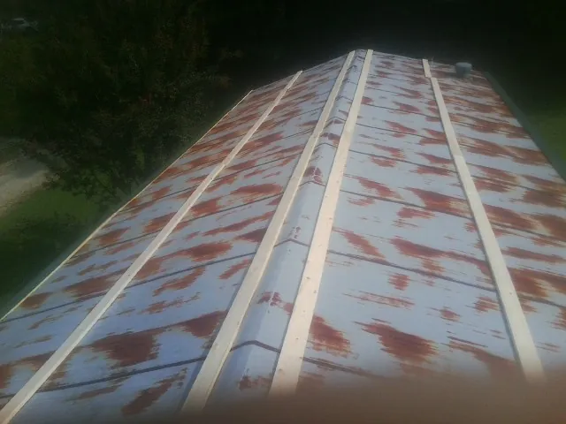 Rusted metal roof panels with new wood purlins before replacement — Storm Damage Roof Repair in La Grange Park by Roofing Brothers