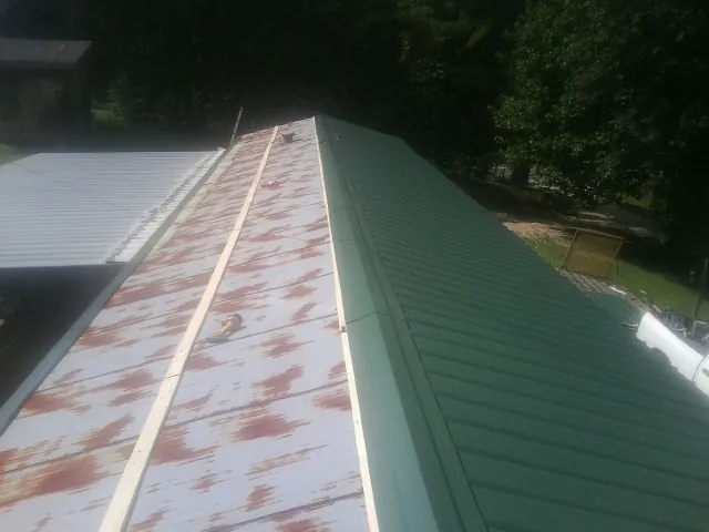 Old rusted panels beside newly installed green metal roofing — Wind Damage Roof Repair by Roofing Brothers in La Grange Park