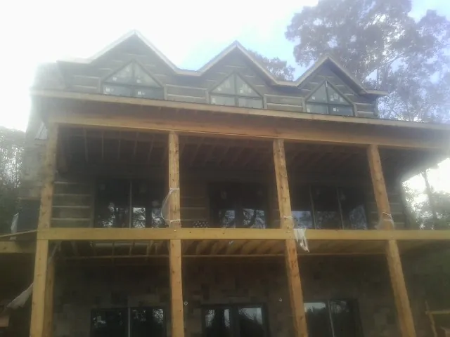 Dormers and porch framing on a large log home under construction — Roof Coating work by our crew in La Grange Park